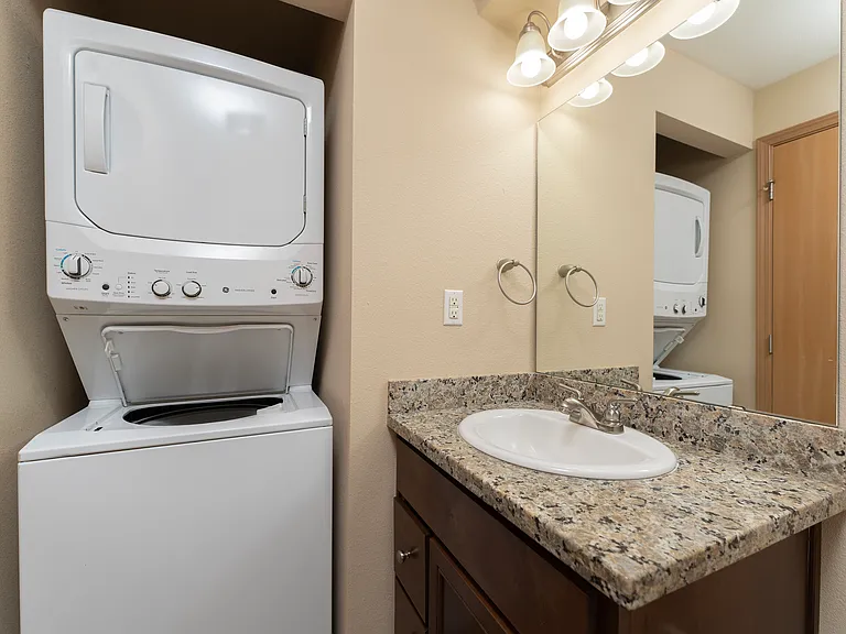 Efficient living meets style with this compact laundry and bathroom setup. Efficient living meets style with this compact laundry and bathroom setup.