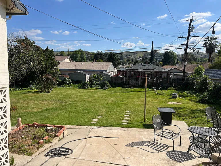 Backyard of the property. Entrance to the unit that is available for rent is to the left of the planter area.