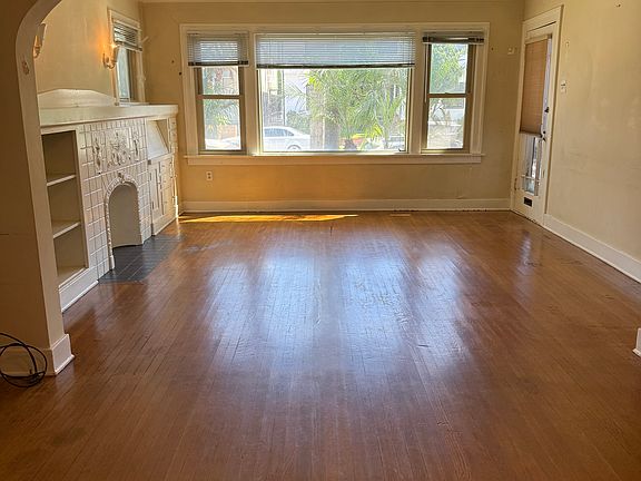 Living room from dining room, decorative fireplace, built-in book cases, and desk on the left
