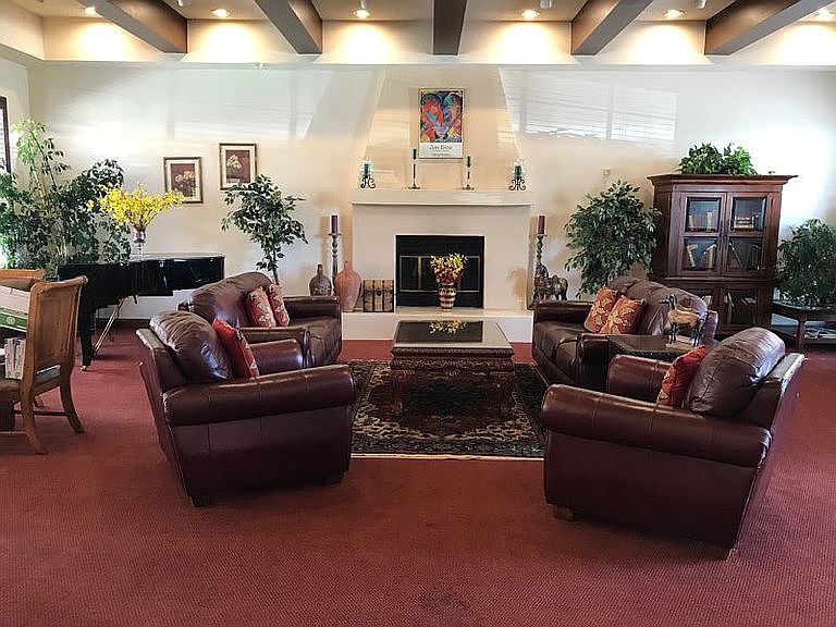 Club house includes grand piano, kitchen, dining area, fireplace, and lending library