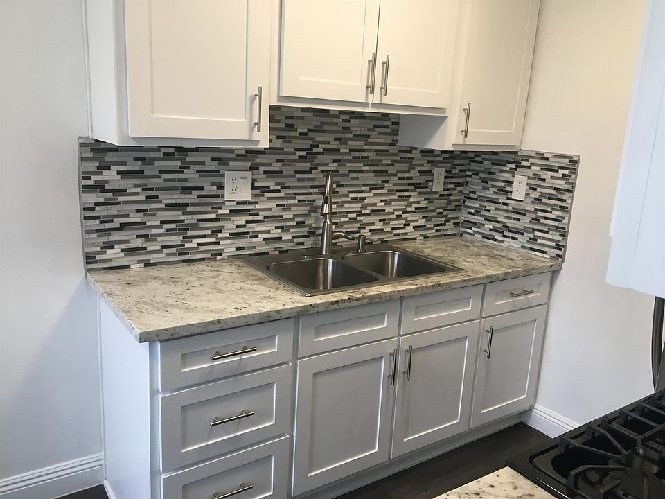 Beautiful remodeled kitchen sink with back-splash, and new kitchen cabinets.