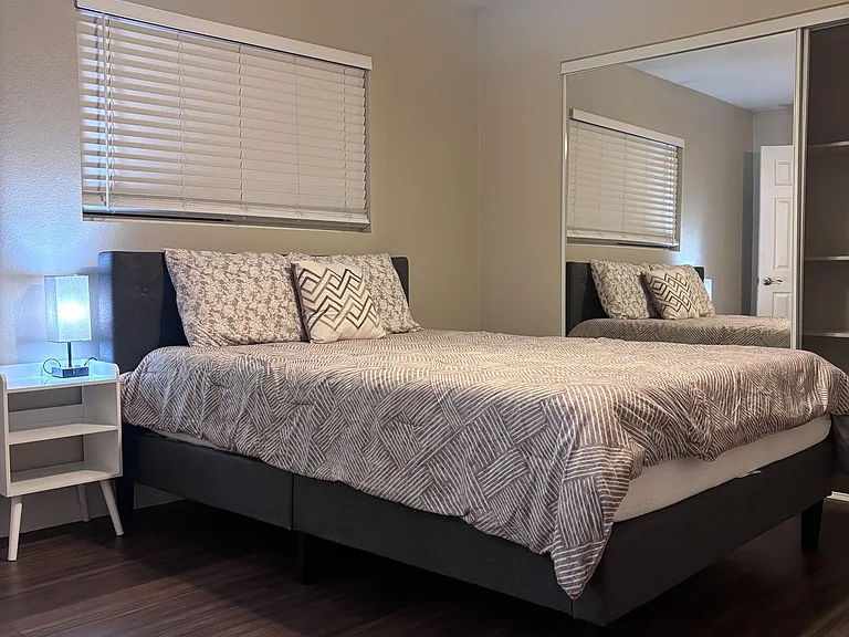 Bed & closet with mirrors is visible