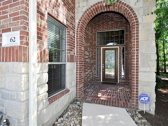 Limestone and brick elevation entry to the home with a pretty leaded glass front door
