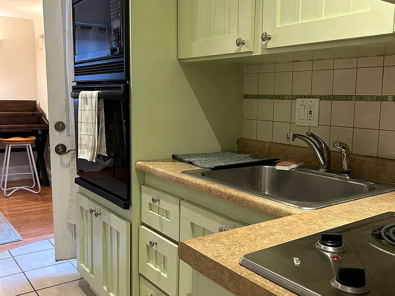 Kitchen with oven, microwave and 2-burner electric stove top.