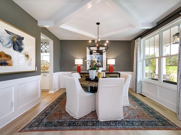 dining room with beam ceiling and wainscoting