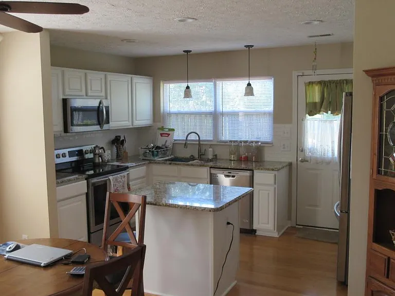 Updated kitchen with granite counter tops and modern lightin