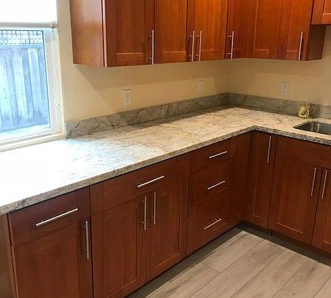 New kitchen with cabinets and granite, and new flooring.