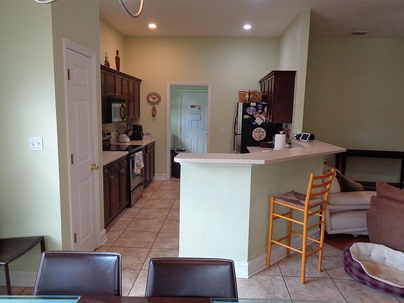 View of the kitchen from the eating area looking through to the garage entry and the conveniently located laundry which has space for a "drop zone" across from the washer/dryer. If you want, the washer/dryer can be included or you can provide your own.