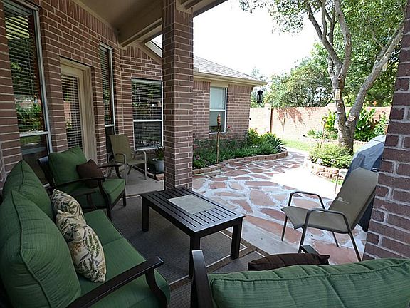 Covered patio area overlooking the fully fenced backyard with lovely landscaping.