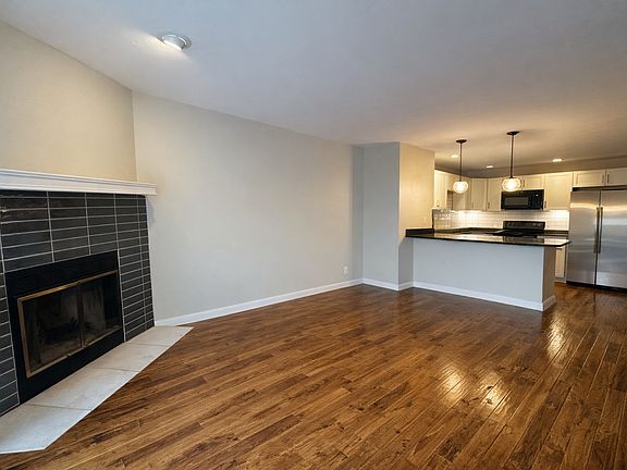 Light-filled, open living room anchored by a classic wood-burning fireplace, creating a warm and inviting gathering space.