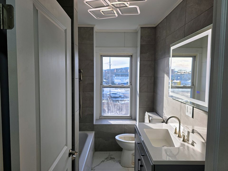 European floor to ceiling tiled bathroom with 3 position shower, LED accent lighting, and touch activated fog proof mirror.