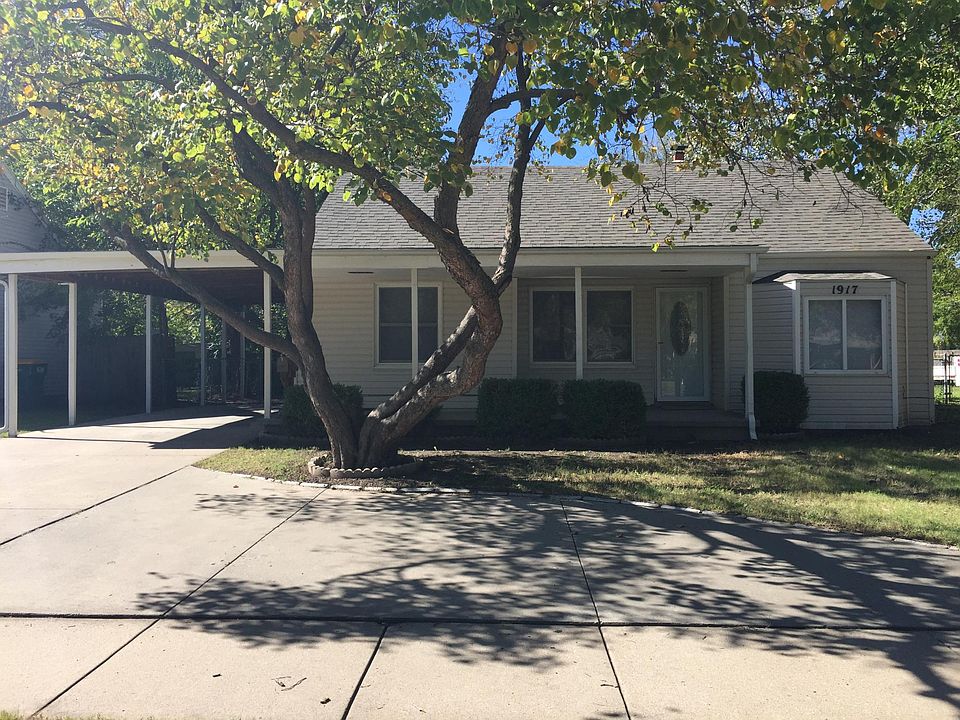 1917 Front - circle drive with extra parking, covered front porch and large carport.