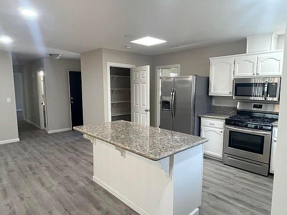 Remodeled Kitchen with pantry, island, granite countertops and stainless steel appliances