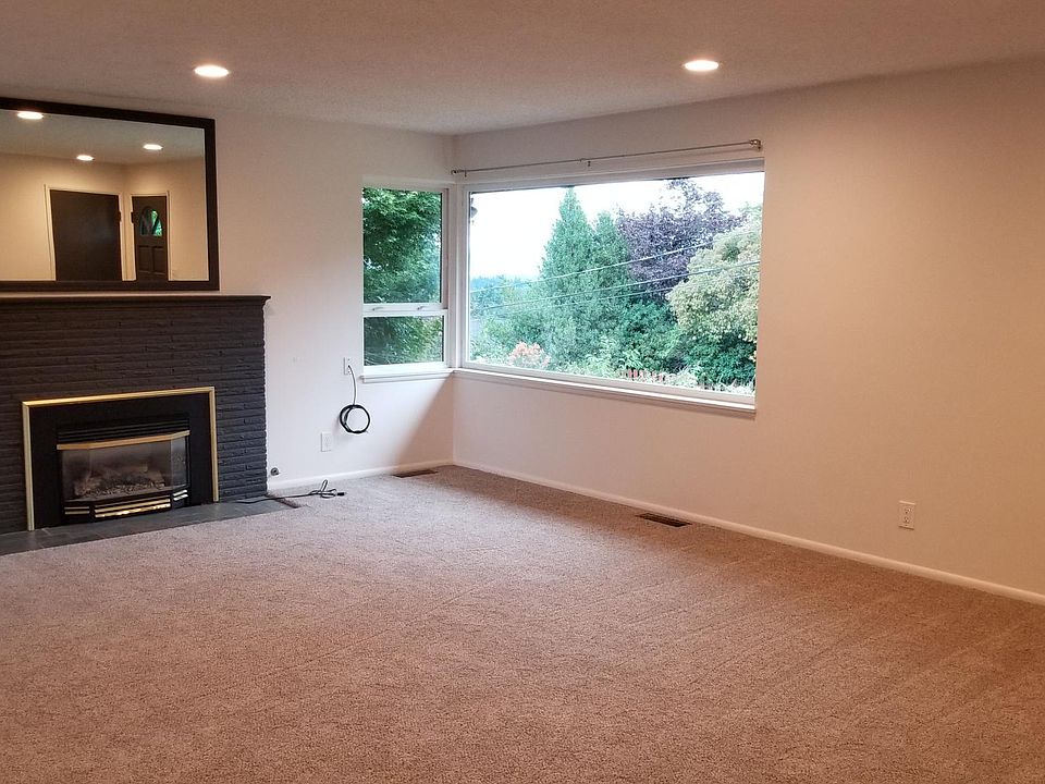 Large living room with fireplace and peek-a-boo view of lake washington