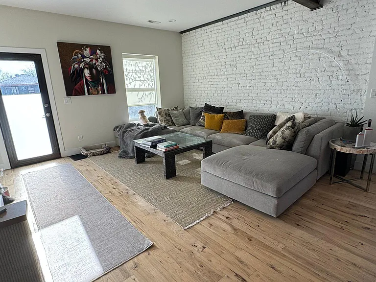 expansive living area off front entry. Original brick wall of the former house.