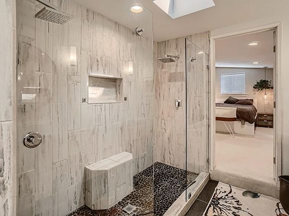 Double head shower with built in seat and glass wall