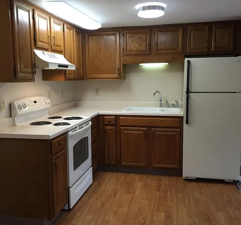 view of kitchen from hallway leading to bathroom and bedroom.