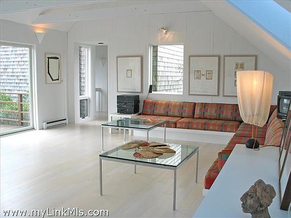 Living/dining room with bleached bamboo floors and 3 sets of glass sliders facing south.