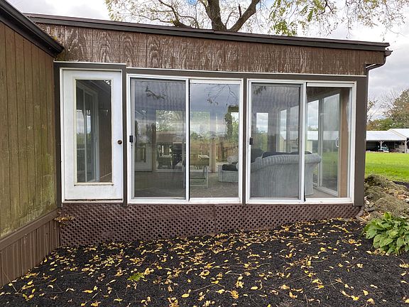 Side of 3 sided glass/screen porch. Surrounded by farms.