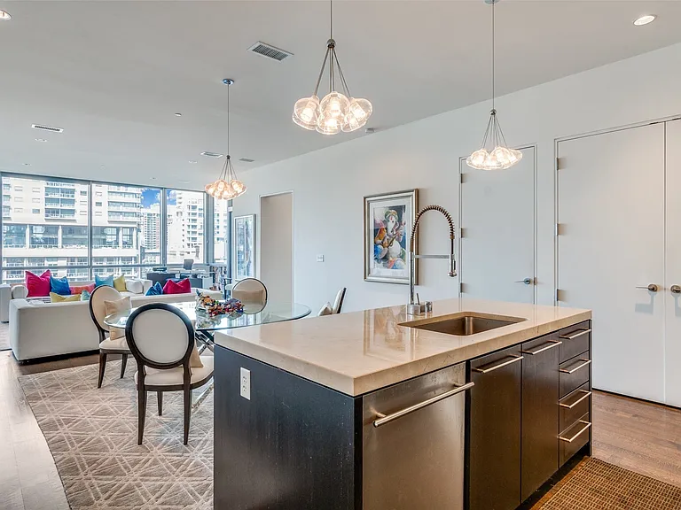 Kitchen with recessed lighting, pendant lighting, light wood finished floors, a wall of windows, and a kitchen island with sink