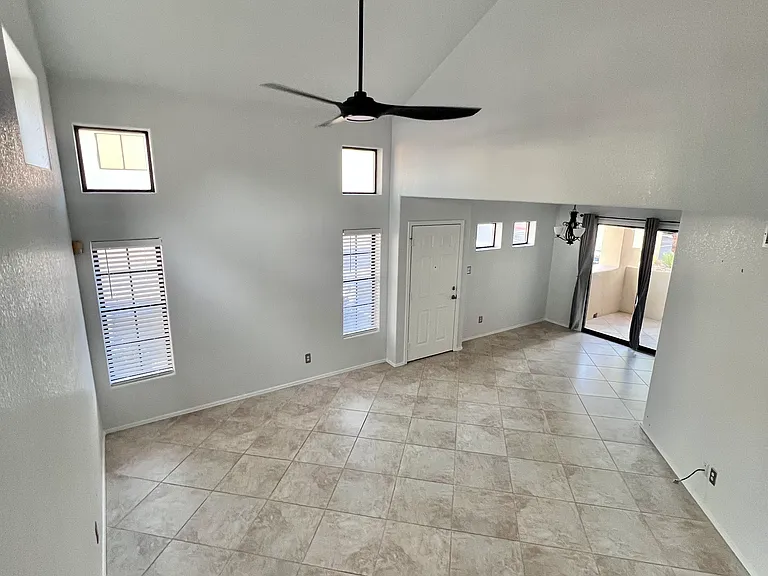 Spacious great room with vaulted ceiling, natural light, oversized tile. New Ceiling fan and white blinds in July 2026