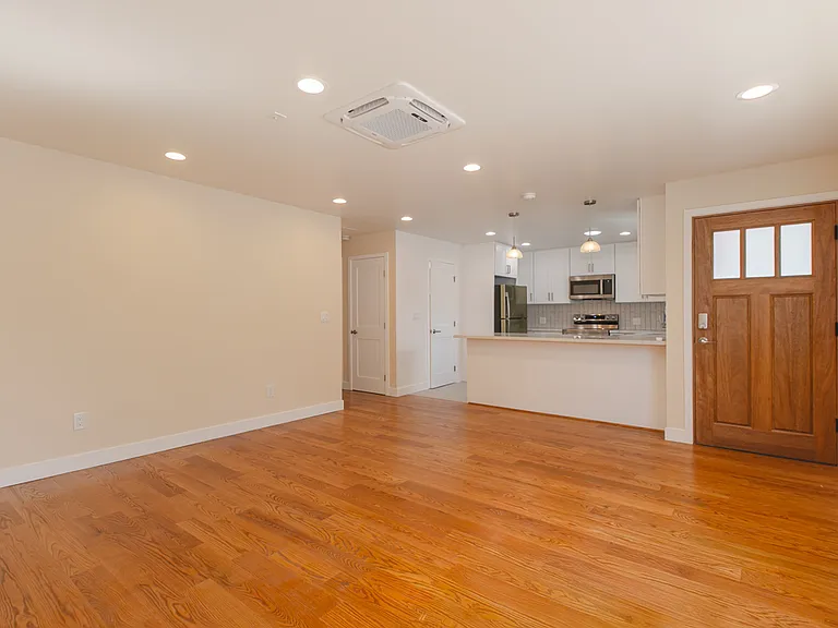 Spacious living room featuring wood floor, AC/Heat and dimming recessed lights.