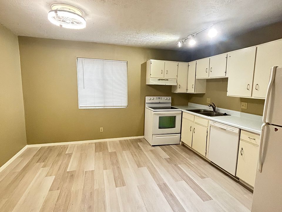 "A clean and spacious kitchen with hardwood floors, thoughtfully separated from the living room to create a sense of organization and natural flow throughout the apartment."
