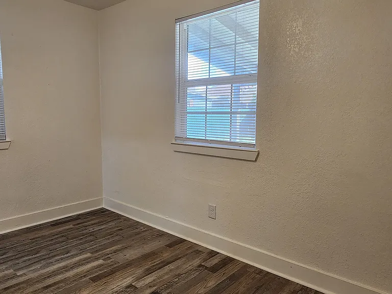 Back bedroom with ceiling fan and new flooring.
