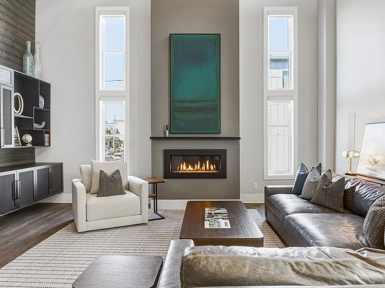 Bright, modern living room with HUGE ceilings. Abundant natural light, plush seating for everyone, a cozy gas fireplace, and a Smart TV_perfect for relaxing.