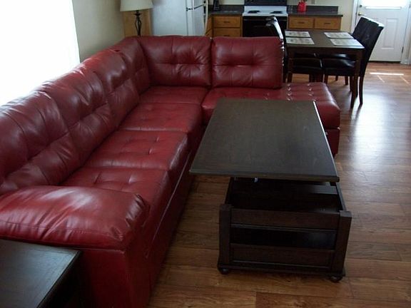 Coffee table top raises for easy access to food while watching TV with friends.