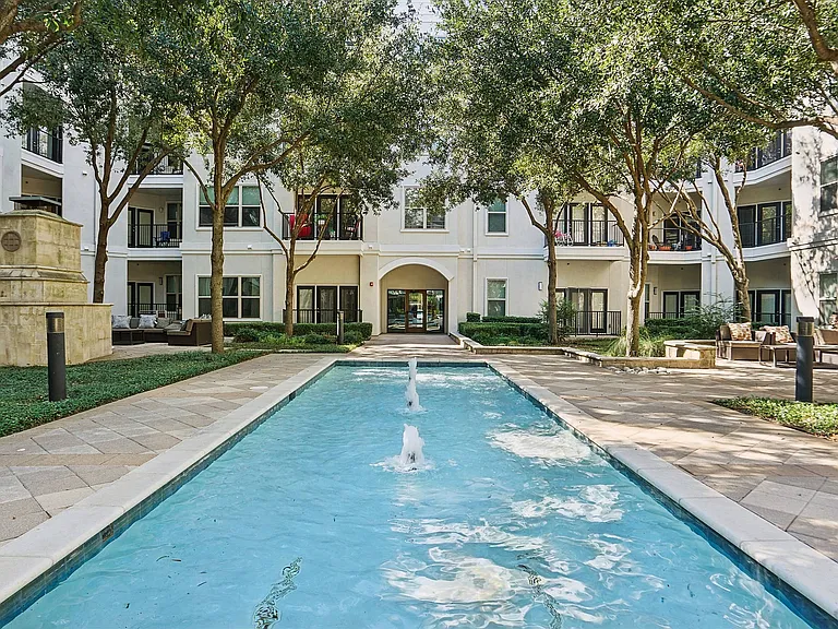 Resort-style swimming pool surrounded by lounge chairs at Addison Keller Springs in Addison, Texas