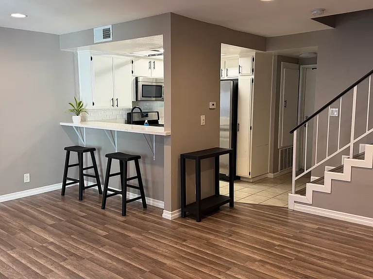 Open concept living room and dining room space with kitchen bar
