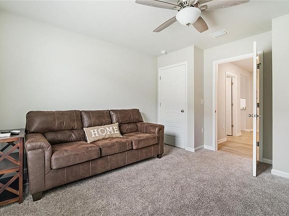 Living room featuring light colored carpet and ceiling fan