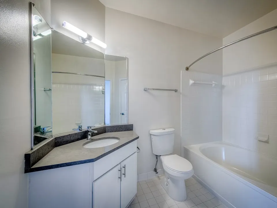 Renovated Package II bathroom with white cabinetry, grey quartz countertop, and hard surface flooring