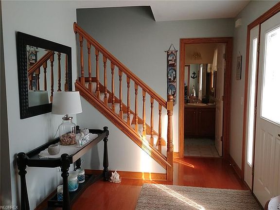Center foyer with warm hardwood floors and railing