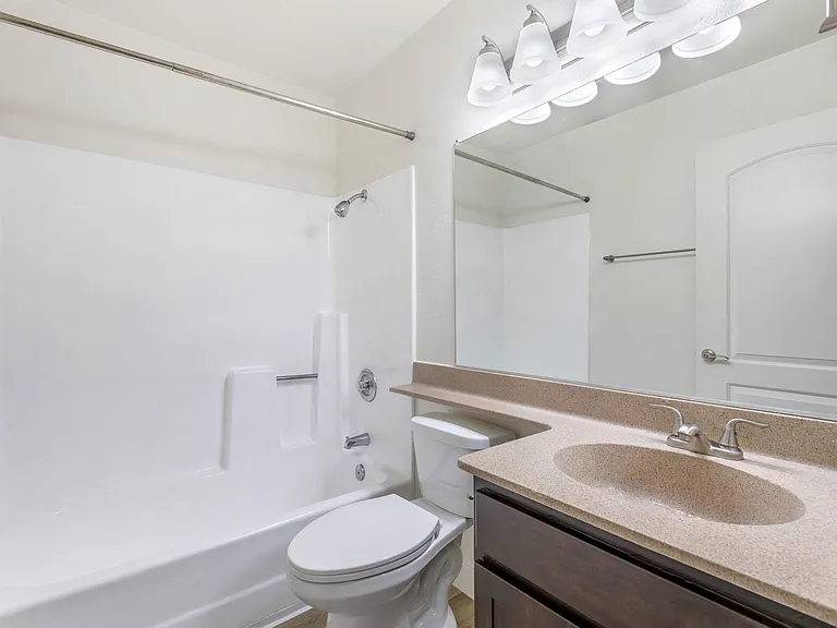 Step into luxury at Independence Plaza: where every bathroom is a retreat, complete with modern fixtures, a sleek sink, a cozy bath, and a mirror that reflects your impeccable taste.