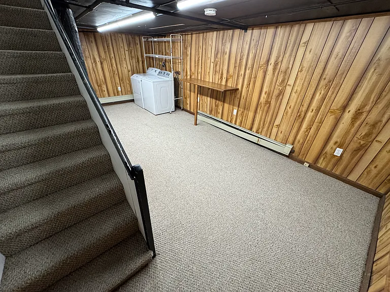 Basement room with laundry machines included.