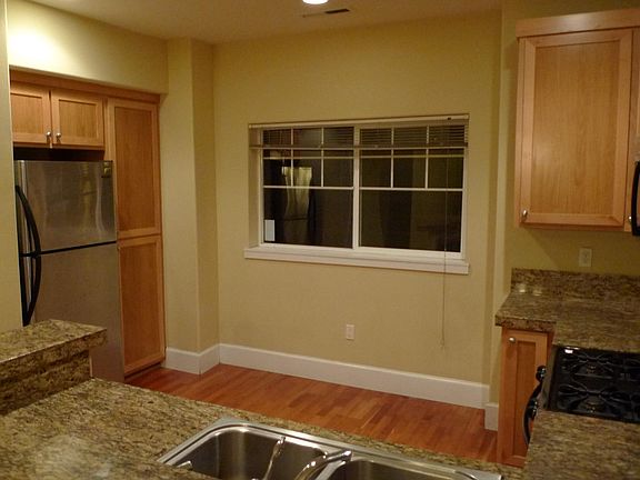 Kitchen with hardwood floor, granite countertop, gas stove and plenty of cabinets spaces