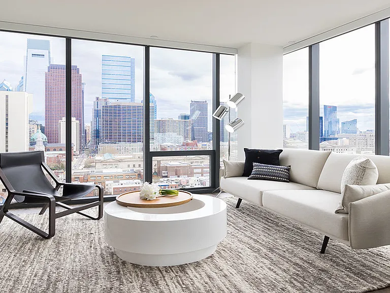 Brightly lit living room surrounded by floor to ceiling windows