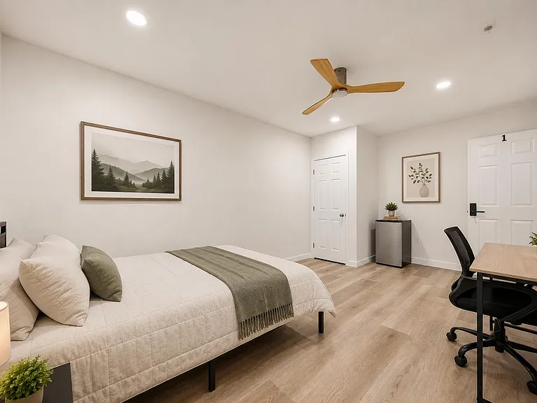 Well-appointed bedroom featuring a full bed, work desk, ceiling fan, and in-room mini fridge for added convenience.