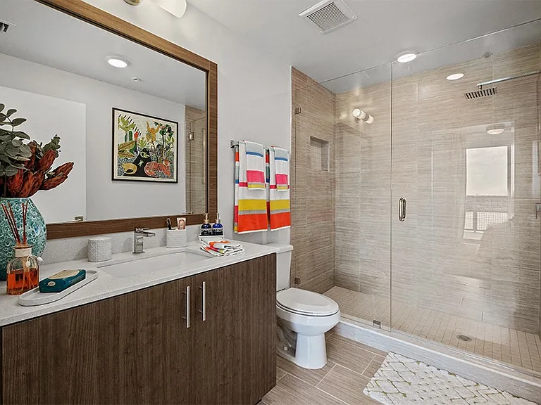 Our modern bathrooms feature framed mirrors and premium quartz countertops