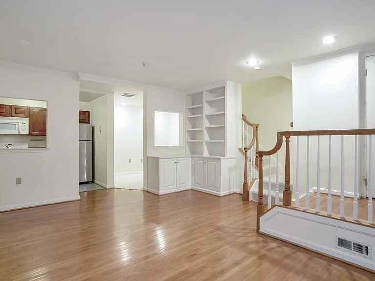 Front door to the right, living space, view of den, stairs to master bedroom on 2nd floor, half bath at bottom of stairs.