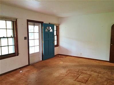 Enter into a large living room. Hardwood floors under the carpet.
