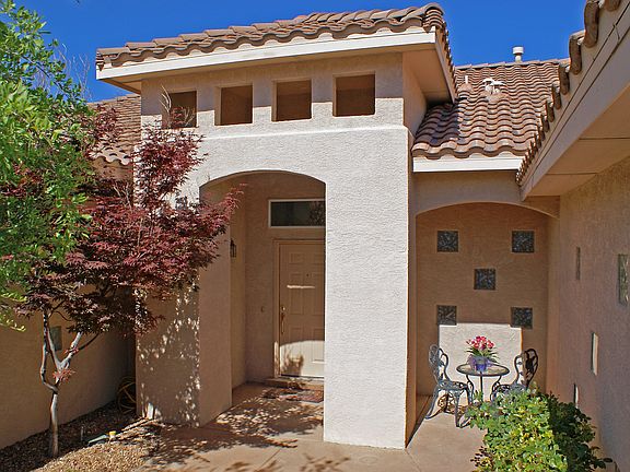 Private courtyard entry with rose bushes and maple tree.