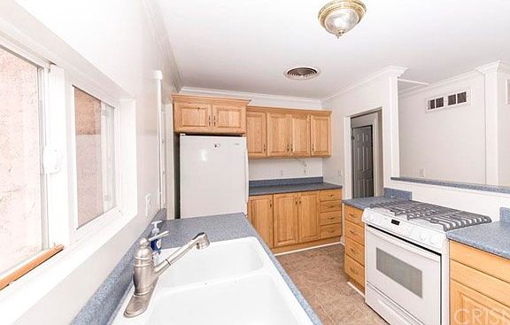 Kitchen close up. Utility Room to the left of fridge. Doorway on right goes to the hall towards bedr