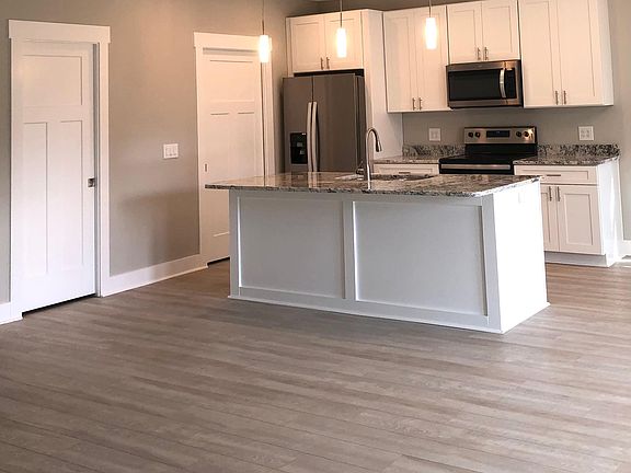 Granite countertops with sink and dishwasher in island.