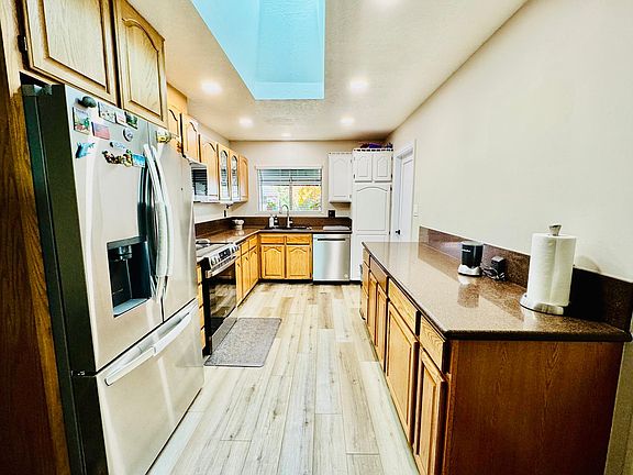 Light-filled kitchen featuring skylights that bring in abundant natural daylight. Functional layout with plenty of counter and cabinet space