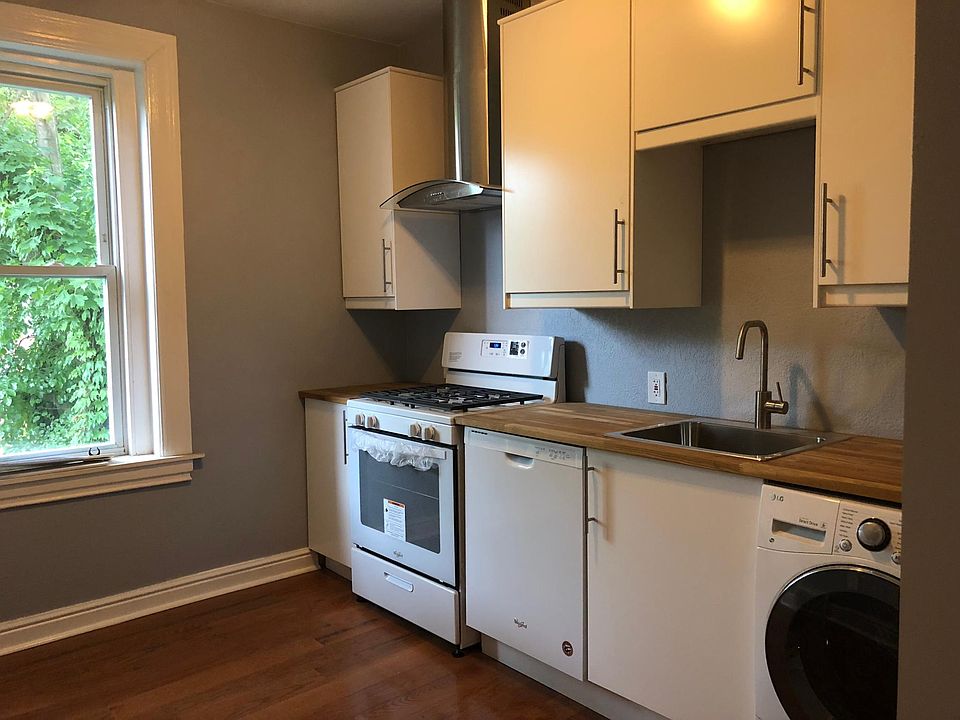 Kitchen with dishwasher, gas range, hood, washer/dryer machine.