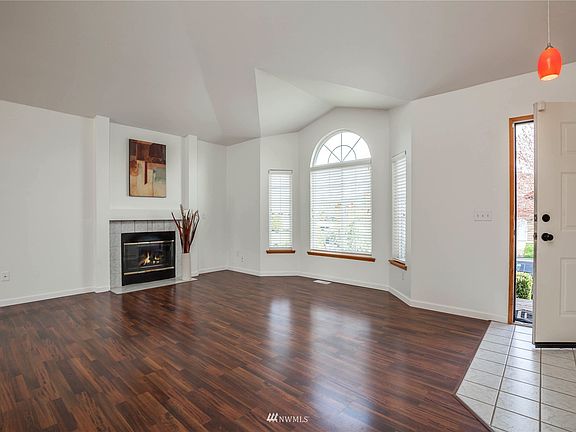 Living room has large windows and gas fireplace