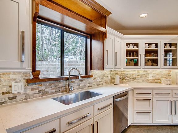 Stunning kitchen with quartz counters, slate tile backsplash, new cabinets & drawers and under counter lighting.